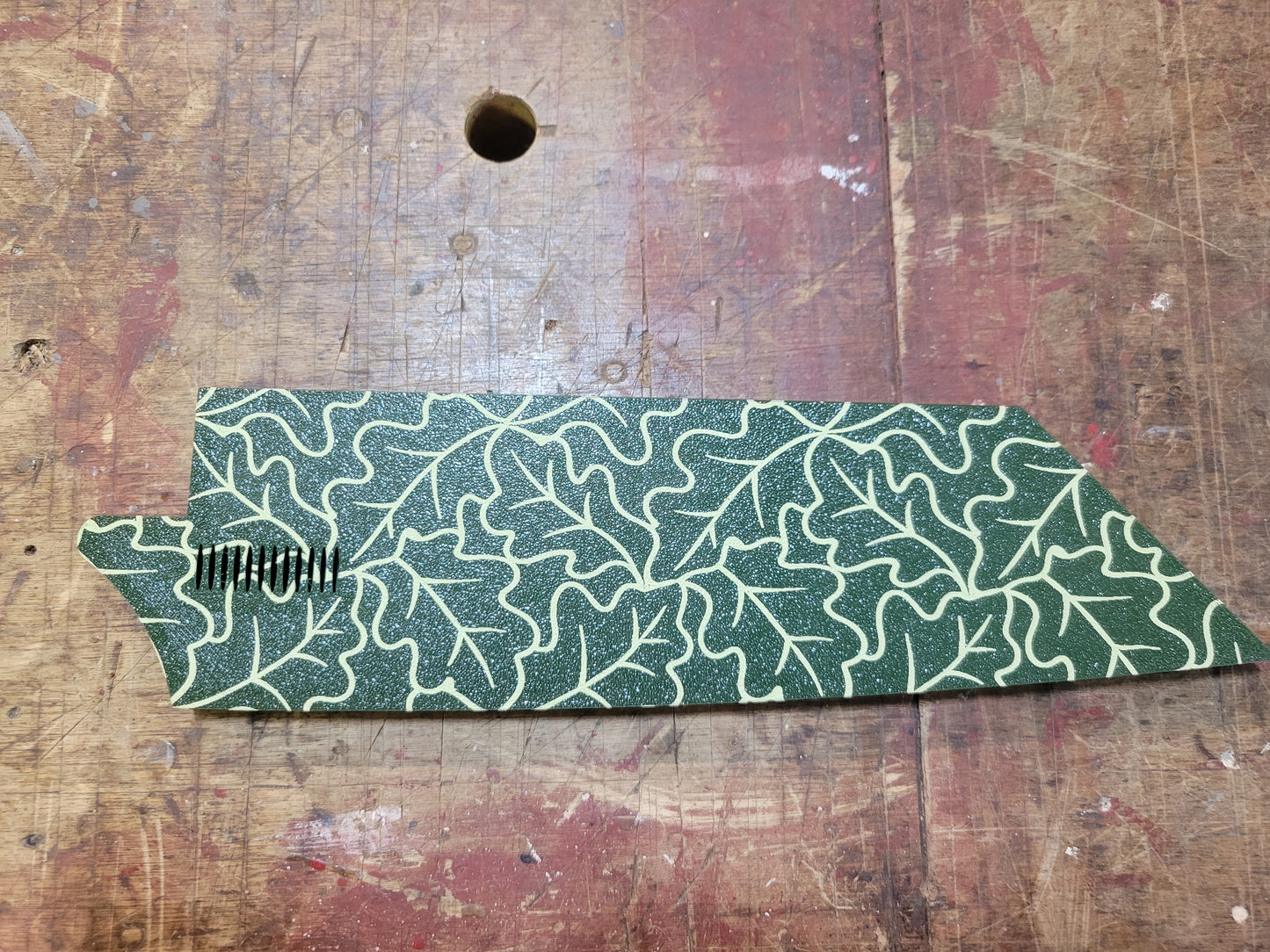 Green leaf-patterned object on a wooden surface